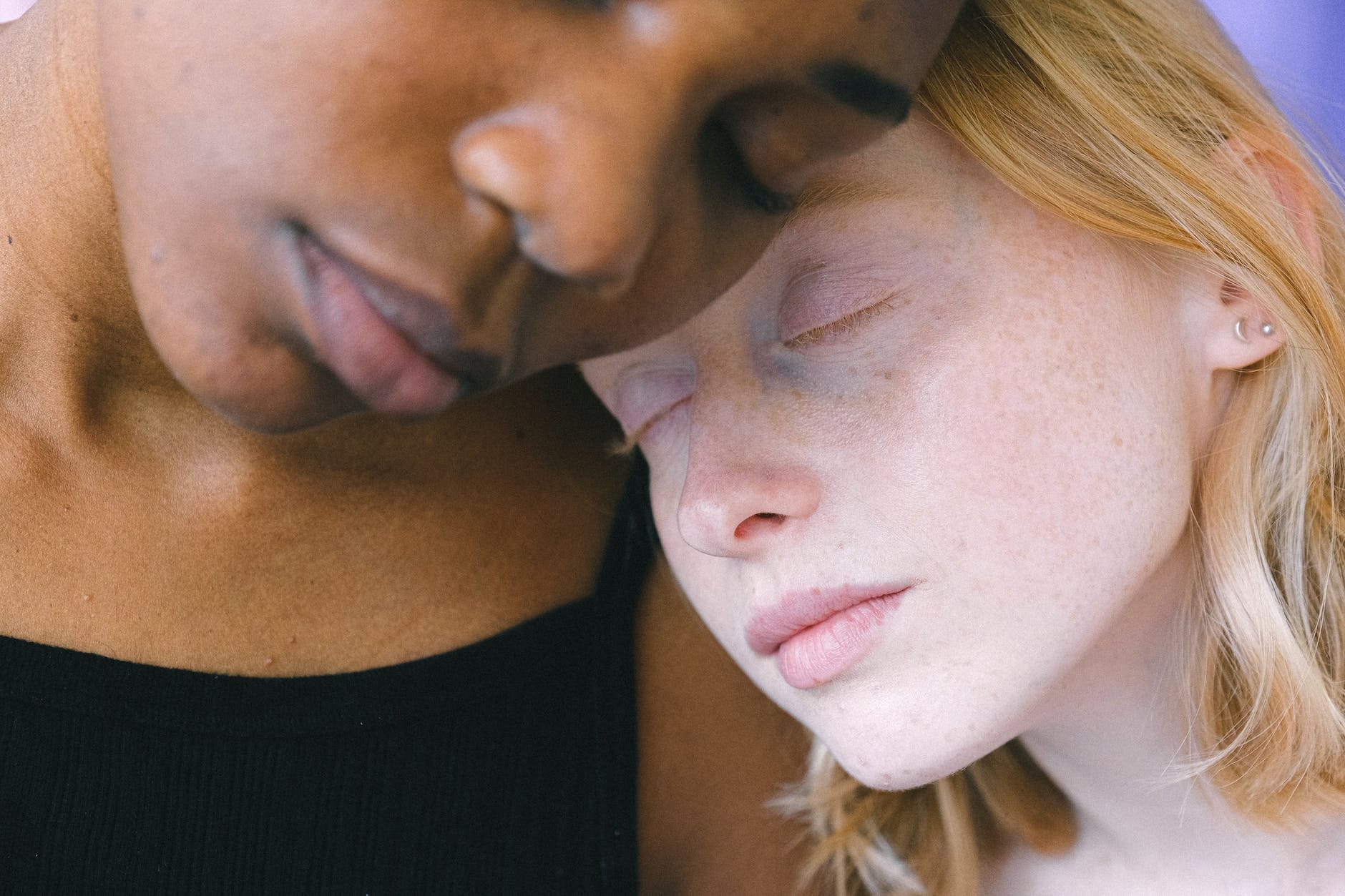 heads of interracial women leaning on each other